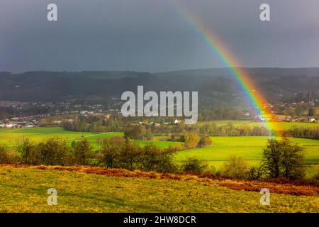 Arcobaleno e cielo scuro con campagna ondulata vicino a Oaker nella zona di Derbyshire Dales del Peak District National Park, Derbyshire, Inghilterra, Regno Unito Foto Stock