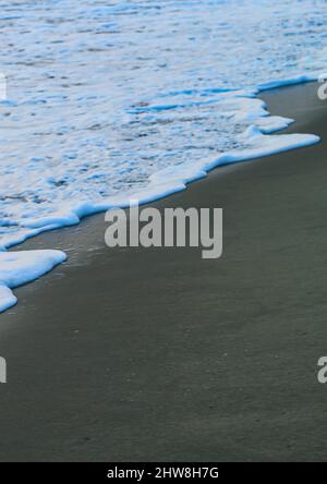 Onda morbida dell'Oceano Blu su Sandy Beach. Per utilizzare lo sfondo. Messa a fuoco selettiva. Spiaggia del mare e onda morbida dell'oceano blu. Giorno d'estate e spiaggia di sabbia. Foto Stock