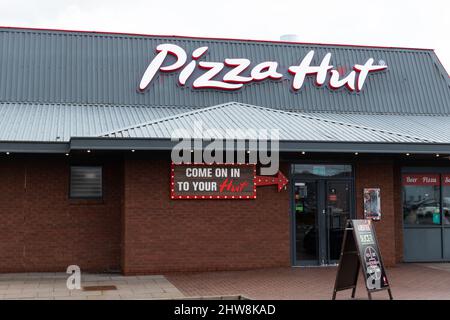 La facciata del negozio e il logo di American Owned Pizza Company, Pizza Hut nel Merry Hill Centre vicino a Brierley Hill nel Regno Unito Foto Stock