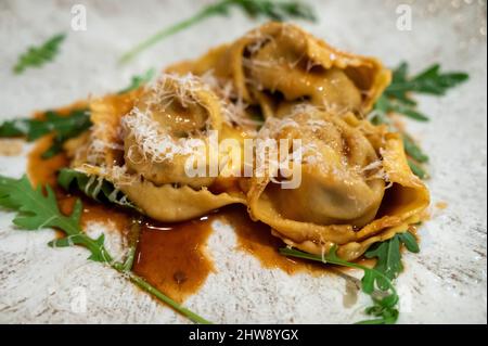 Piatti italiani, ravioli di guancia di vitello con formaggio parmigiano grattugiato e balsamico da vicino Foto Stock