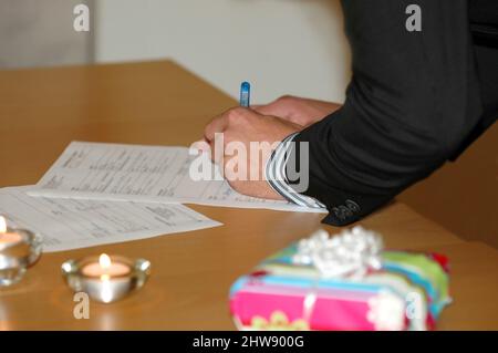 Lo sposo sta firmando il contratto di nozze. Foto Stock