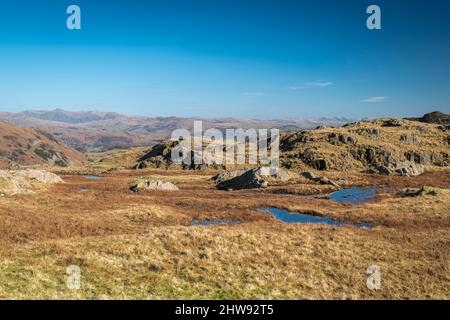 Un'immagine HDR soleggiata, invernale e paesaggistica che guarda ad est attraverso le colline di lakeland con le lontane colline di Howgill, Cumbria, Inghilterra. 01 marzo 2022 Foto Stock