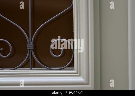 Antica casa neoclassica porta d'ingresso in legno con griglie in ferro battuto realizzate a mano a Nafplio, Grecia. Foto Stock