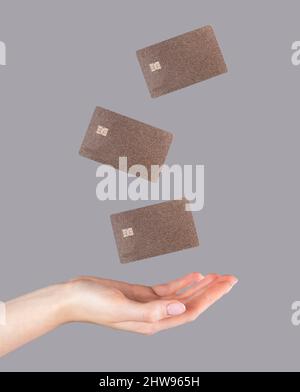 Carte di debito a mano e a levitating di plastica della donna. Concetto di shopping online, prenotazione, esecuzione di transazioni bancarie. Foto di alta qualità Foto Stock