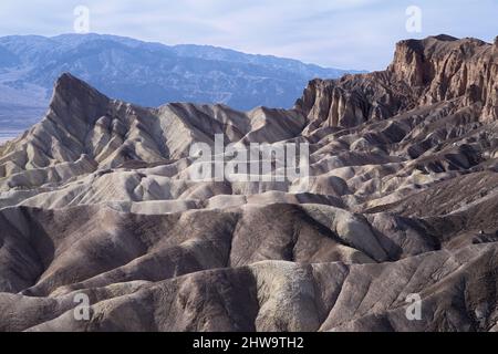 Zabriskie Point nel Parco Nazionale della Valle della morte che mostra Manly Beacon e la catena montuosa Panamint sullo sfondo. Foto Stock
