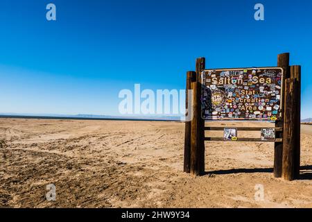 Cartello per l'area ricreativa del mare di Salton coperta di adesivi per renderlo quasi illeggibile sulla costa orientale del mare di Salton vicino a Bombay Beach. Foto Stock