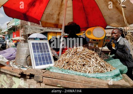 Un venditore di strada carica la sua lampada solare alimentata dalla strada di Kibera baraccopoli. Nelle baraccopoli di Kibera, la maggior parte dei residenti, in particolare i venditori ambulanti, le scuole private, le organizzazioni non governative, le luci di strada e le scuole, utilizzano tutti il sistema di energia solare a basso costo, che è una fonte di energia più affidabile e a basso costo. Ciò ha reso più facile il riciclaggio della maggior parte dell'energia elettrica consumata dai residenti e ha anche contribuito a ridurre l'elevato numero di morti che si verificano a causa delle scosse elettriche e degli incendi di slum quotidiani. Foto Stock