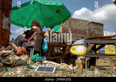 Un venditore di strada siede vicino al suo commercio di strada mentre carica la sua lampada ad energia solare nelle baraccopoli di Kibera. Nelle baraccopoli di Kibera, la maggior parte dei residenti, in particolare i venditori ambulanti, le scuole private, le organizzazioni non governative, le luci di strada e le scuole, utilizzano tutti il sistema di energia solare a basso costo, che è una fonte di energia più affidabile e a basso costo. Ciò ha reso più facile il riciclaggio della maggior parte dell'energia elettrica consumata dai residenti e ha anche contribuito a ridurre l'elevato numero di morti che si verificano a causa delle scosse elettriche e degli incendi di slum quotidiani. (Foto di Donwilson Odhiambo/SOPA Images/Sipa USA) Foto Stock