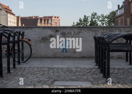 Vista di una gravità blu su un muro in biciclette parcheggio contro edifici e cielo blu Foto Stock