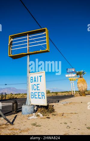 Due cartelli stradali alti e fatiscenti con la loro segnaletica principale rotta e mancante lungo l'autostrada California 111 da Bombay Beach vicino al Salton S. Foto Stock