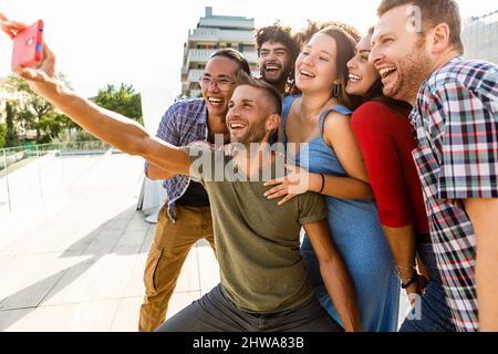 Giovani amici multirazziali che scattano una foto selfie con il telefono cellulare Foto Stock