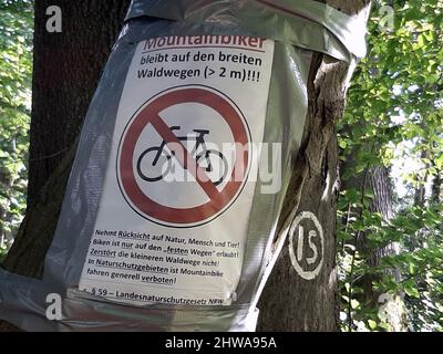 Poster su un tronco di albero, facendo appello ai bikers di montagna per aderire alle regole nella foresta, Germania Foto Stock