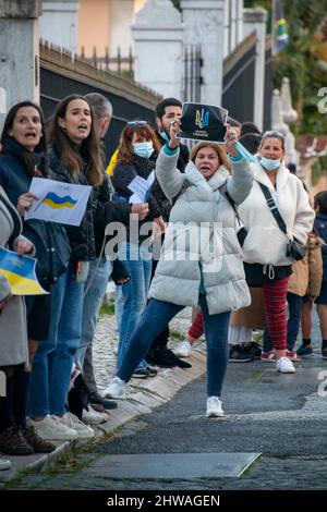 Lisbona, Portogallo. 04th Mar 2022. Gli attivisti hanno dei segni a sostegno del popolo ucraino durante un raduno contro l'invasione russa. L'evento è stato organizzato dall'Associazione degli ucraini in Portogallo di fronte all'ambasciata del governo cinese. Durante l'azione, sono stati visualizzati messaggi che chiedevano ai governi di opporsi fermamente all'aggressione contro l'Ucraina. Questa protesta mira anche a dimostrare la solidarietà della comunità portoghese e Ucraina che vive nel paese. Credit: SOPA Images Limited/Alamy Live News Foto Stock