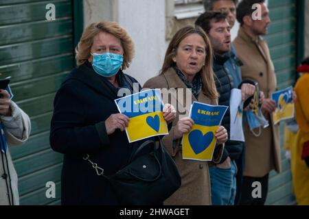 Lisbona, Portogallo. 04th Mar, 2022. Diversi attivisti hanno segni a sostegno del popolo ucraino durante un raduno contro l'invasione russa. L'evento è stato organizzato dall'Associazione degli ucraini in Portogallo di fronte all'ambasciata del governo cinese. Durante l'azione, sono stati visualizzati messaggi che chiedevano ai governi di opporsi fermamente all'aggressione contro l'Ucraina. Questa protesta mira anche a dimostrare la solidarietà della comunità portoghese e Ucraina che vive nel paese. Credit: SOPA Images Limited/Alamy Live News Foto Stock