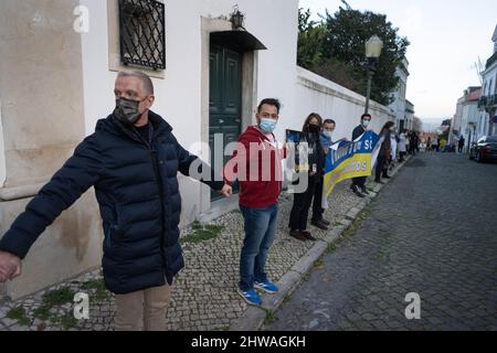 Lisbona, Portogallo. 04th Mar 2022. Gli attivisti stringono le mani in solidarietà con il popolo ucraino durante un raduno contro l'invasione russa. L'evento è stato organizzato dall'Associazione degli ucraini in Portogallo di fronte all'ambasciata del governo cinese. Durante l'azione, sono stati visualizzati messaggi che chiedevano ai governi di opporsi fermamente all'aggressione contro l'Ucraina. Questa protesta mira anche a dimostrare la solidarietà della comunità portoghese e Ucraina che vive nel paese. (Foto di Jorge Castellanos/SOPA Images/Sipa USA) Credit: Sipa USA/Alamy Live News Foto Stock