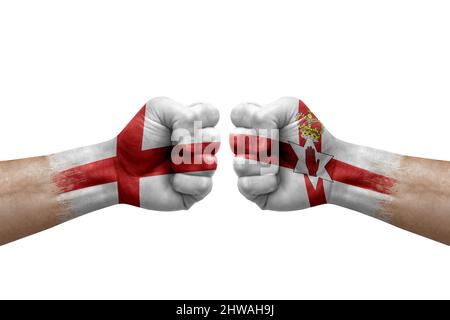 Due mani si pugno l'una all'altra su sfondo bianco. Le bandiere di paese dipinse i pugni, concetto di crisi di conflitto tra l'inghilterra e l'irlanda Foto Stock