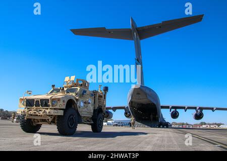 I membri del servizio dell'esercito degli Stati Uniti assegnati alla Divisione di fanteria 3rd si preparano a caricare un veicolo tattico Joint Light su un'Air Force C-17 Globemaster III per un dispiegamento nell'area operativa dell'Europa e dell'Africa, presso l'Hunter Army Airfield, Georgia, 2 marzo 2022. La squadra di combattimento Armored Brigade del 1st, con sede a Fort Stewart, 3rd ID, si reagirà in Germania per rassicurare gli alleati della NATO, scoraggiare l'aggressione russa e prepararsi a sostenere una serie di altri requisiti nella regione. (STATI UNITI Esercito foto di Capt. John Howard) Foto Stock