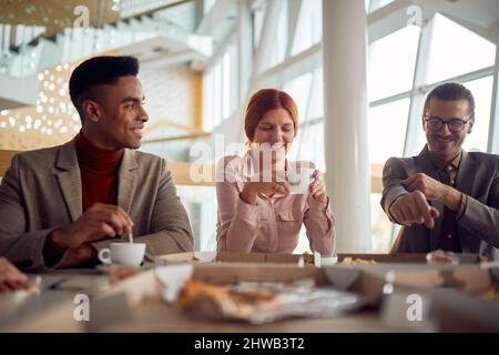 Una giovane donna allegra ama il caffè con i suoi colleghi maschi dopo una pausa pranzo in un'atmosfera piacevole nella costruzione dell'azienda. Affari, Foto Stock