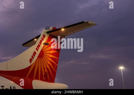 Parte di coda di un Alliance Air ATR 72 nell'ex livrea regionale Air India contro cielo nuvoloso sera Foto Stock