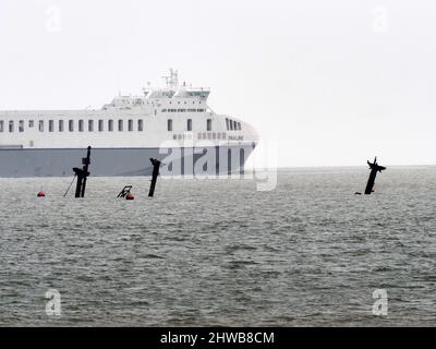 Sheerness, Kent, Regno Unito. 5th Mar 2022. Il naufragio della SS Richard Montgomery è stato raffigurato da 3 angolazioni sulla marea ultra-bassa di questa mattina (altezza prevista 0,31m) che affondò 1,5 miglia a Sheerness nel Kent nel 1944. I tre montanti e i due rack di poppa possono essere visti su queste maree ultra basse (normalmente si vede solo il rack di poppa in avanti). I 3 alberi saranno tagliati quest'estate. PIC: Guardando Nord-Est dal lungomare vicino ai moli di Sheerness. Nave Paolina passando nel canale del Tamigi. Credit: James Bell/Alamy Live News Foto Stock