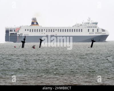 Sheerness, Kent, Regno Unito. 5th Mar 2022. Il naufragio della SS Richard Montgomery è stato raffigurato da 3 angolazioni sulla marea ultra-bassa di questa mattina (altezza prevista 0,31m) che affondò 1,5 miglia a Sheerness nel Kent nel 1944. I tre montanti e i due rack di poppa possono essere visti su queste maree ultra basse (normalmente si vede solo il rack di poppa in avanti). I 3 alberi saranno tagliati quest'estate. PIC: Guardando Nord-Est dal lungomare vicino ai moli di Sheerness. Nave Paolina passando nel canale del Tamigi. Credit: James Bell/Alamy Live News Foto Stock