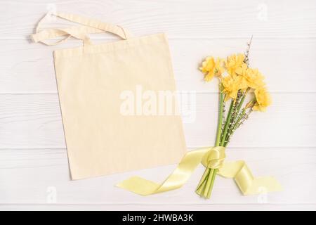 Mockup pasquale con borsa tote bianca e bouquet giallo Foto Stock