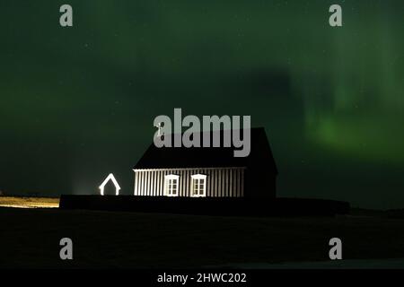 Aurora boreale sopra il faro di Garður e le chiese Foto Stock