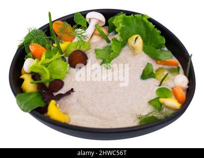 Zuppa cremosa con funghi shiitake, funghi Oyster, miele agarics champignon e servito in tazza nera con verdi e verdure. Isolato su bianco backgr Foto Stock