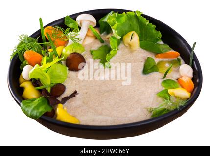 Zuppa cremosa con funghi shiitake, funghi Oyster, miele agarics champignon e servito in tazza nera con verdi, verdure e baguette di granella. Isolato o Foto Stock