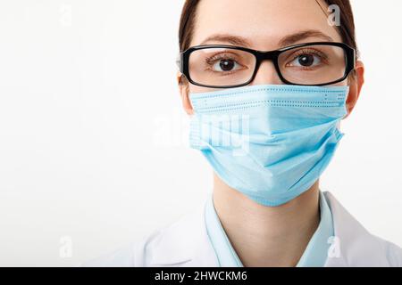 Ritratto di un medico in una maschera medica su sfondo bianco Foto Stock