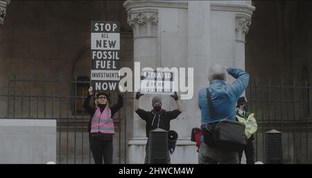 Londra, UK - 11 20 2021: Due attivisti climatici che hanno tenuto in mano i segnali di protesta fuori dalla Corte reale di giustizia di Strand, per una protesta insulata della Gran Bretagna. Foto Stock