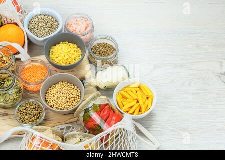 Vari prodotti biologici vegetariani in vasetti di vetro su sfondo bianco di legno. Zero negozi di rifiuti e stile di vita sustanable concetto. Vista dall'alto, copia Foto Stock