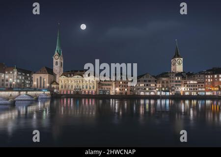 Skyline di Zurigo di notte con la Chiesa di Fraumunster e la Chiesa di San Pietro - Zurigo, Svizzera Foto Stock