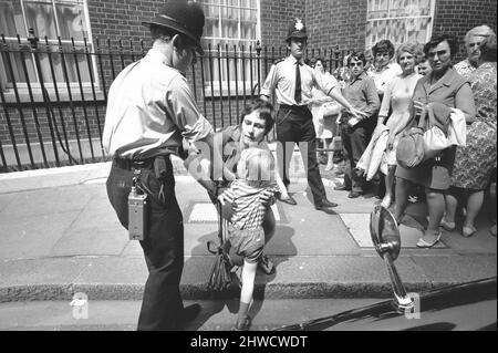 La polizia si è mossa per arrestare il peso di Angela Hilary, dopo che ha gettato la vernice rossa sopra il primo ministro Edward Heath fuori di numero 10 Downing Street. 25th giugno 1970. Foto Stock