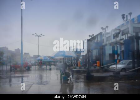 Immagine sfocata di Howrah, Bengala Occidentale, India. Sparato attraverso il vetro bagnato del parabrezza dell'automobile, riscossione di tassa di pedaggio al ponticello di Hoogly 2nd. Immagine stock monsone. Foto Stock