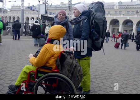 Non esclusiva: ODESA, UCRAINA - 4 MARZO 2022 - tre donne con zaini rimangono sulla piattaforma prima della partenza della Odesa-Lviv-Rakhiv evacuati Foto Stock