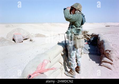 Un soldato egiziano osserva il confine del Kuwait per le truppe irachene lungo il muro di confine di sabbia che separa il Kuwait dall'Arabia Saudita 8 febbraio 1991 ad Ar Ruqi, Arabia Saudita. I soldati egiziani fanno parte della coalizione di nazioni nell'operazione Desert Storm per liberare il Kuwait dall'occupazione irachena. Foto Stock