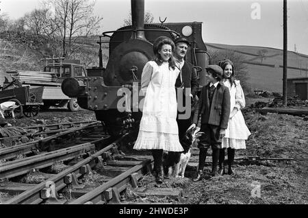 Le telecamere rotolarono, la scena fu impostata e l'azione iniziò quando lungo arrivò Shep. Le collie sedevano nel mezzo della pista mentre "The Railway Children" veniva girato a Haworth, nello Yorkshire. Dopo essere stato Coaxed via il cane è stato guardato dalla polizia locale Sgt. Nelle foto sono Jenny Agutter, Bernard Cribbins, Gary Warren e Sally Thomsett con il cane. 11th maggio 1970. Foto Stock