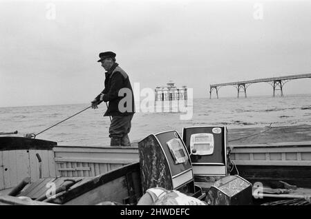 Tre banditi armati uno che sono stati maroonati per un fine settimana a Clevedon, Somerset, sono stati salvati in barca. Ma altre quattro slot machine dovevano essere lasciate indietro quando i mari agitato renevano l'operazione troppo pericolosa. Piermaster Bernard Faraway, di 50 anni, ha guidato l'operazione di salvataggio. La testa del molo è stata tagliata fuori dalla terraferma una settimana fa, quando una sezione del molo del 200ft è crollata durante le prove di sicurezza. Un'indagine commissionata dal Clevedon Council s per decidere se riparare o demolire il molo lungo 1000ft. 23rd ottobre 1970. Foto Stock