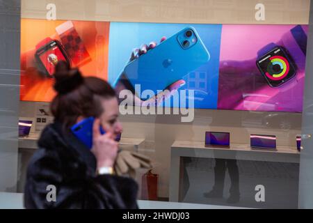 Mosca, Russia. 5th marzo 2022 Una ragazza cammina lungo la strada sullo sfondo della pubblicità dei prodotti Apple di Apple Store chiuso Apple dopo la sanzione contro la Russia in via Tverskaya a Mosca, Russia Foto Stock