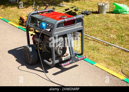 Generatore di benzina. Apparecchiatura per l'alimentazione di corrente. Mezzi di generazione di elettricità. Attrezzature su strada. Foto Stock