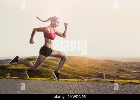 Scatto di una giovane donna sportiva che runing e jumping Foto Stock