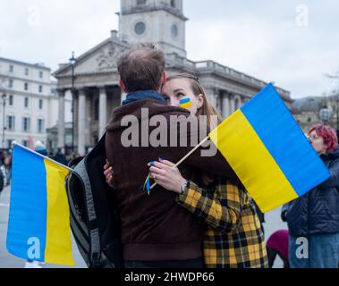 LONDRA, 05 2022 MARZO, i manifestanti che detengono bandiere ucraine abbracciano durante una protesta contro l'invasione dell'Ucraina da parte della Russia su Trafalgar Square Credit: Lucy North/Alamy Live News Foto Stock