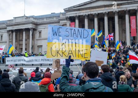 LONDRA, 05 2022 MARZO, Un manifestante ha un cartello con la scritta "Siamo in piedi con l'Ucraina” per protestare contro l'invasione dell'Ucraina da parte della Russia a Trafalgar Square. Credit: Lucy North/Alamy Live News Foto Stock