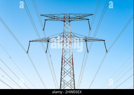 Cavi ad alta tensione in una torre di trasmissione per la distribuzione di energia elettrica. Foto Stock