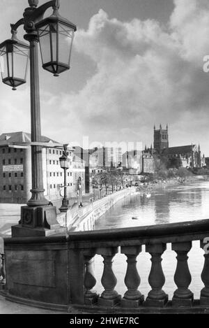 Worcester pittoresco, guardando oltre uno dei bei standard di lampade sul ponte New Road al South Quay alberato e la Cattedrale riflessa nelle acque alte d'inverno del fiume Severn. 1970. Foto Stock