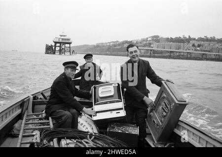 Tre banditi armati uno che sono stati maroonati per un fine settimana a Clevedon, Somerset, sono stati salvati in barca. Ma altre quattro slot machine dovevano essere lasciate indietro quando i mari agitato renevano l'operazione troppo pericolosa. Piermaster Bernard Faraway, di 50 anni, ha guidato l'operazione di salvataggio. La testa del molo è stata tagliata fuori dalla terraferma una settimana fa, quando una sezione del molo del 200ft è crollata durante le prove di sicurezza. Un'indagine commissionata dal Clevedon Council s per decidere se riparare o demolire il molo lungo 1000ft. Bernard è raffigurato con Roy Lovelock e Bill Cooke. 23rd ottobre 1970. Foto Stock