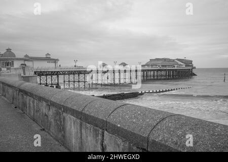 Foto in bianco e nero catturata lungo la spianata di Cromer e il molo di epoca vittoriana nella cittadina balneare di Cromer sulla costa nord del Norfolk Foto Stock