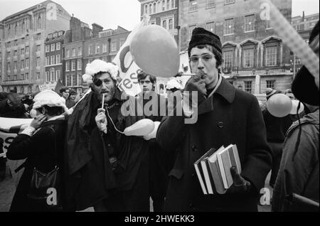 Gli studenti della London School of Ecomonics (LSE) tornano alle lezioni in stile fiero, ma festivo. Si riunì al Lincoln's Inn per marciare verso Kingsway verso il LSE. Alla testa della colonna c'era un gruppo di 'giudici' dello studente spazzato e gowned che portava un'effigie del dottor Adams. Altri studenti marciarono in catene di carta, fischietti soffianti ecc. 19th febbraio 1969. Foto Stock