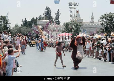 Scene al parco a tema Disneyland ad Anaheim, California, Stati Uniti. Personaggi del libro della giungla Mowgli e Baloo durante la sfilata della strada principale. Giugno 1970. Foto Stock